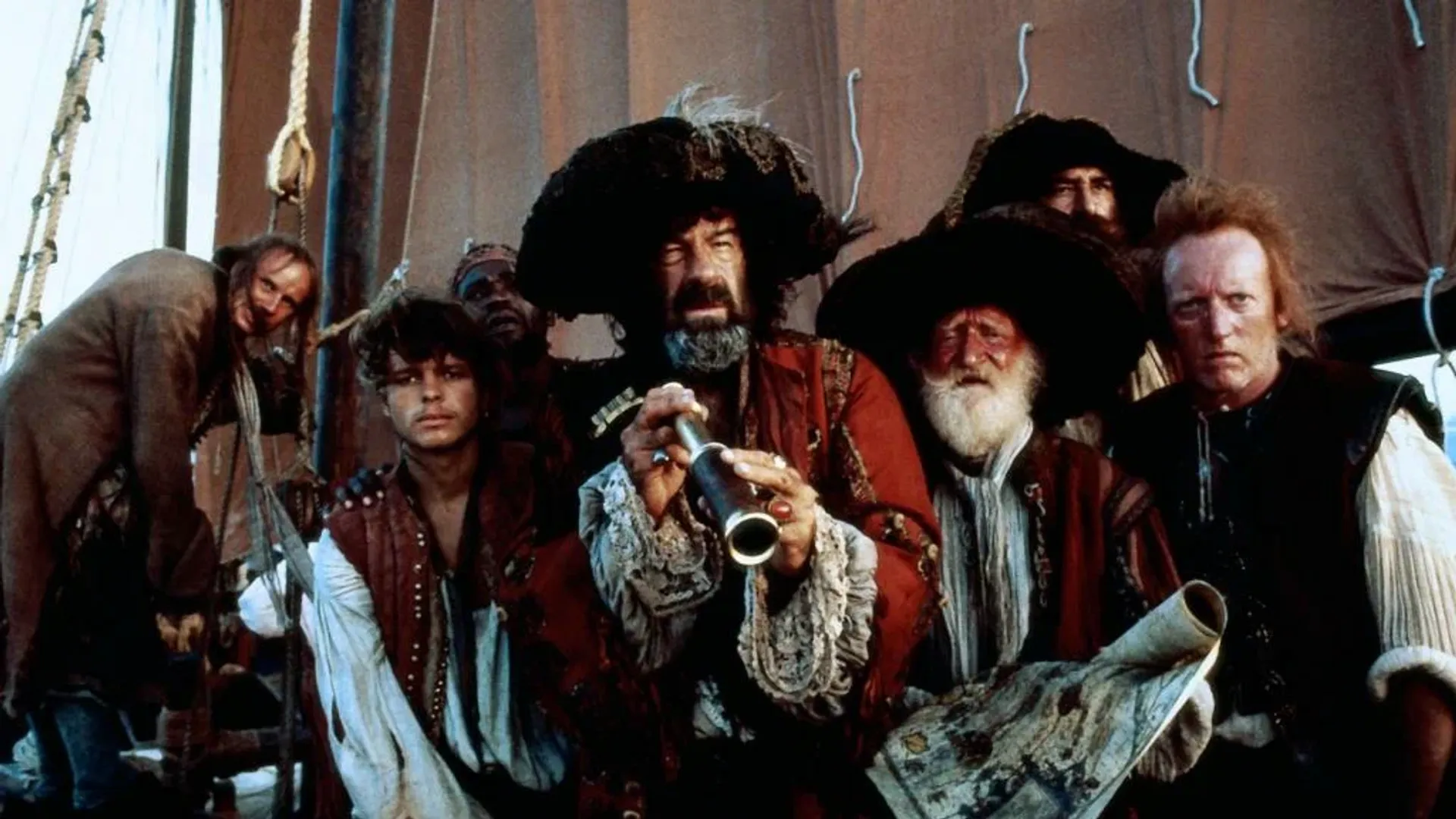 Un grupo de piratas en la cubierta de un barco, el capitán con un sombrero de tres picos sosteniendo un catalejo y un mapa, la tripulación con expresiones serias