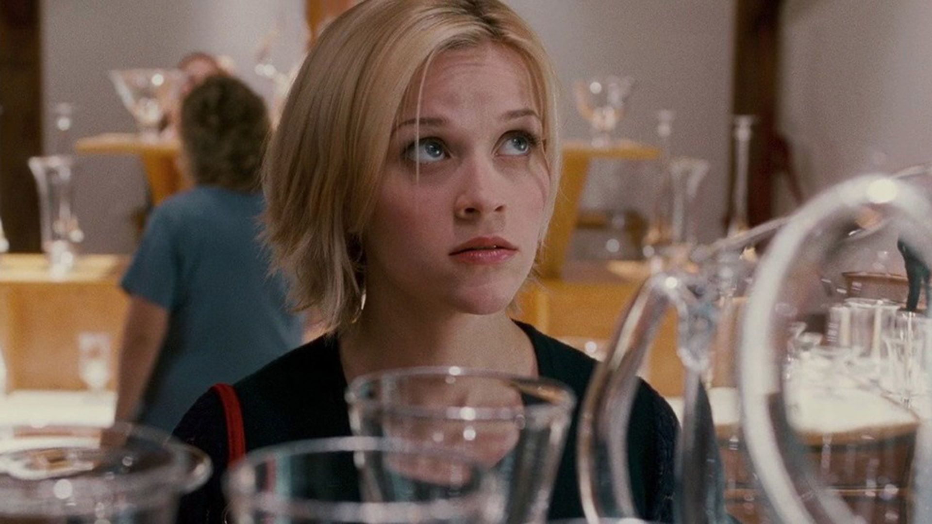 Reese Witherspoon con un corte de pelo corto mirando pensativamente hacia arriba