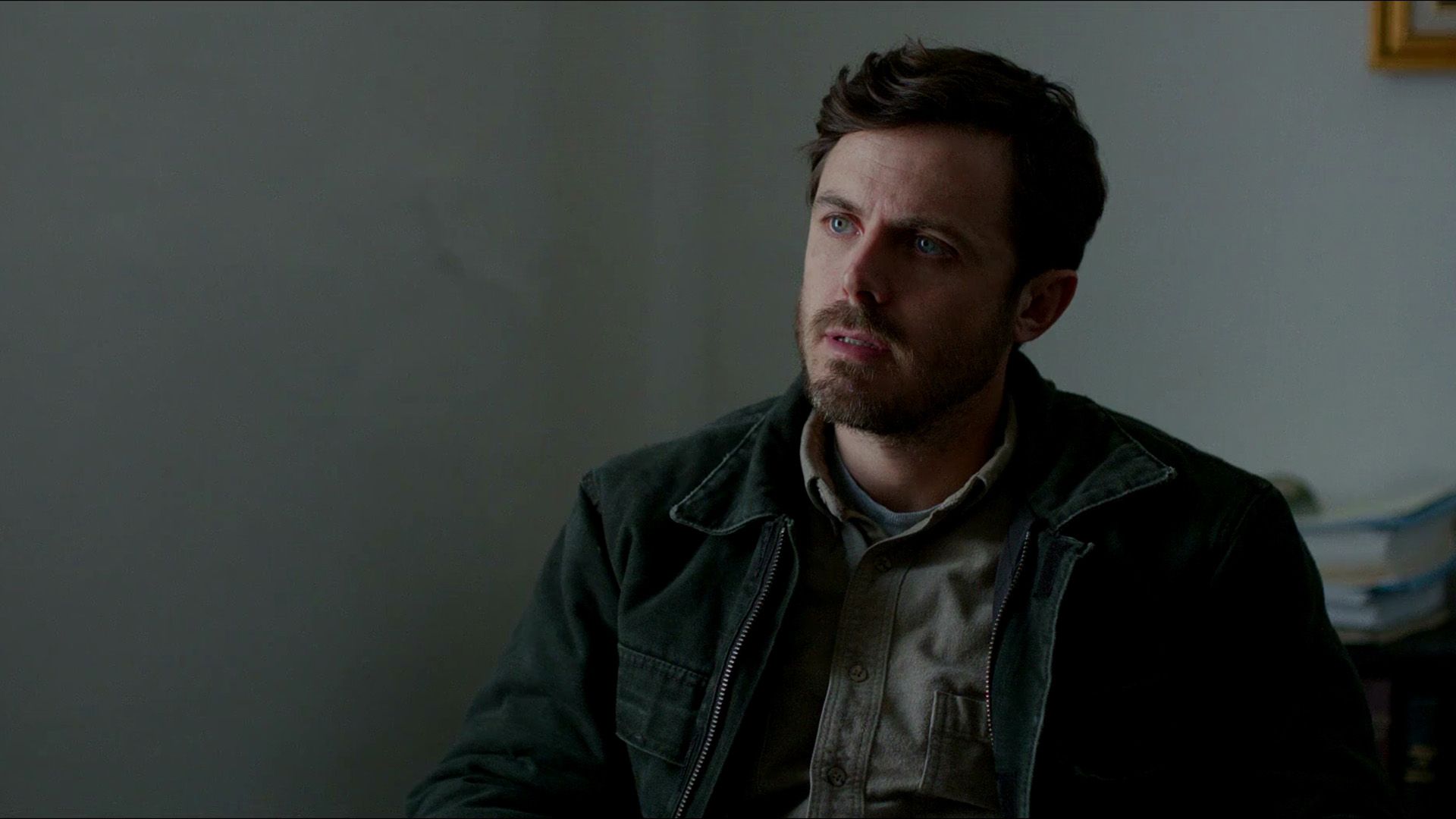 Actor Casey Affleck en una chaqueta verde oscuro en una escena de la película "Manchester by the Sea"