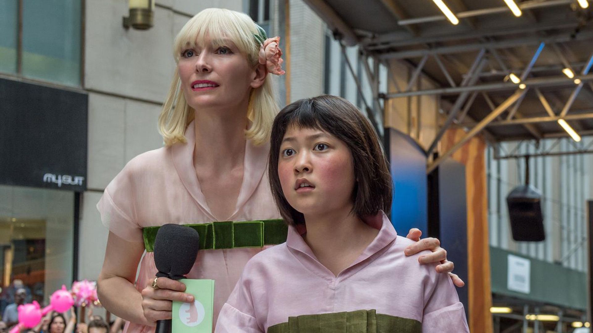 Tilda Swinton with long white hair holds An Seo-hyun by the shoulders