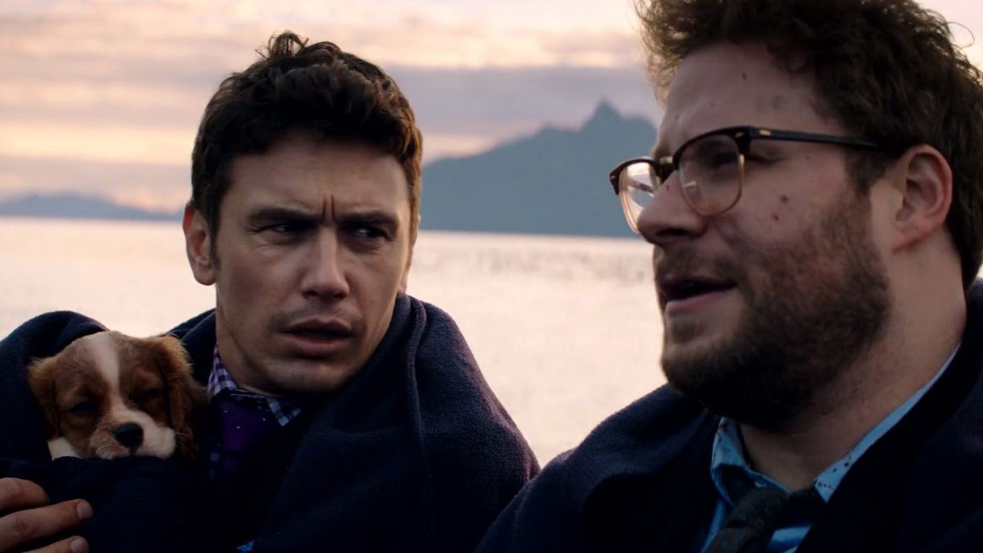 James Franco con un cachorro en sus brazos mira a Seth Rogen