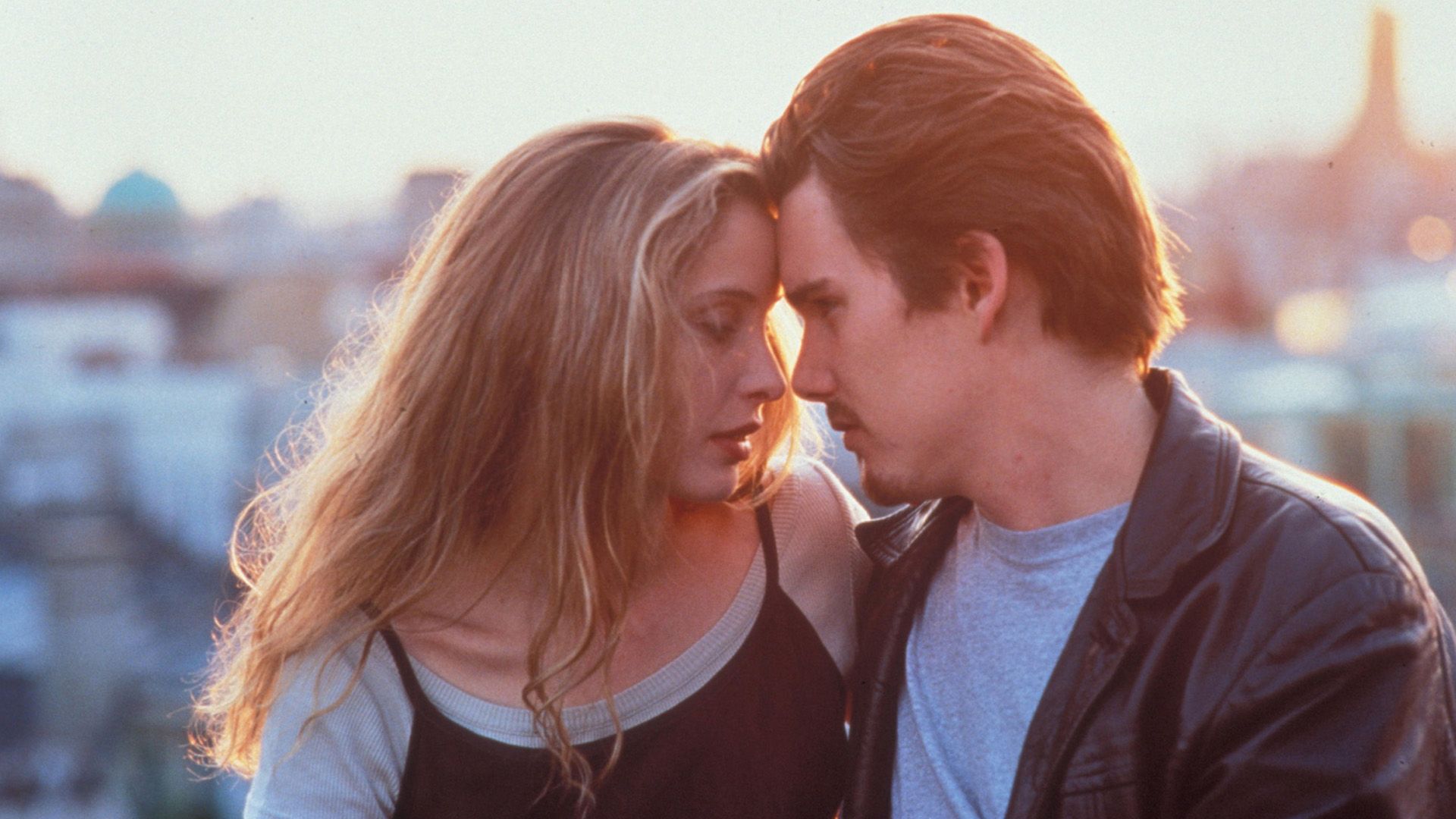 Ethan Hawke y Julie Delpy apoyando sus frentes juntos contra el fondo del amanecer