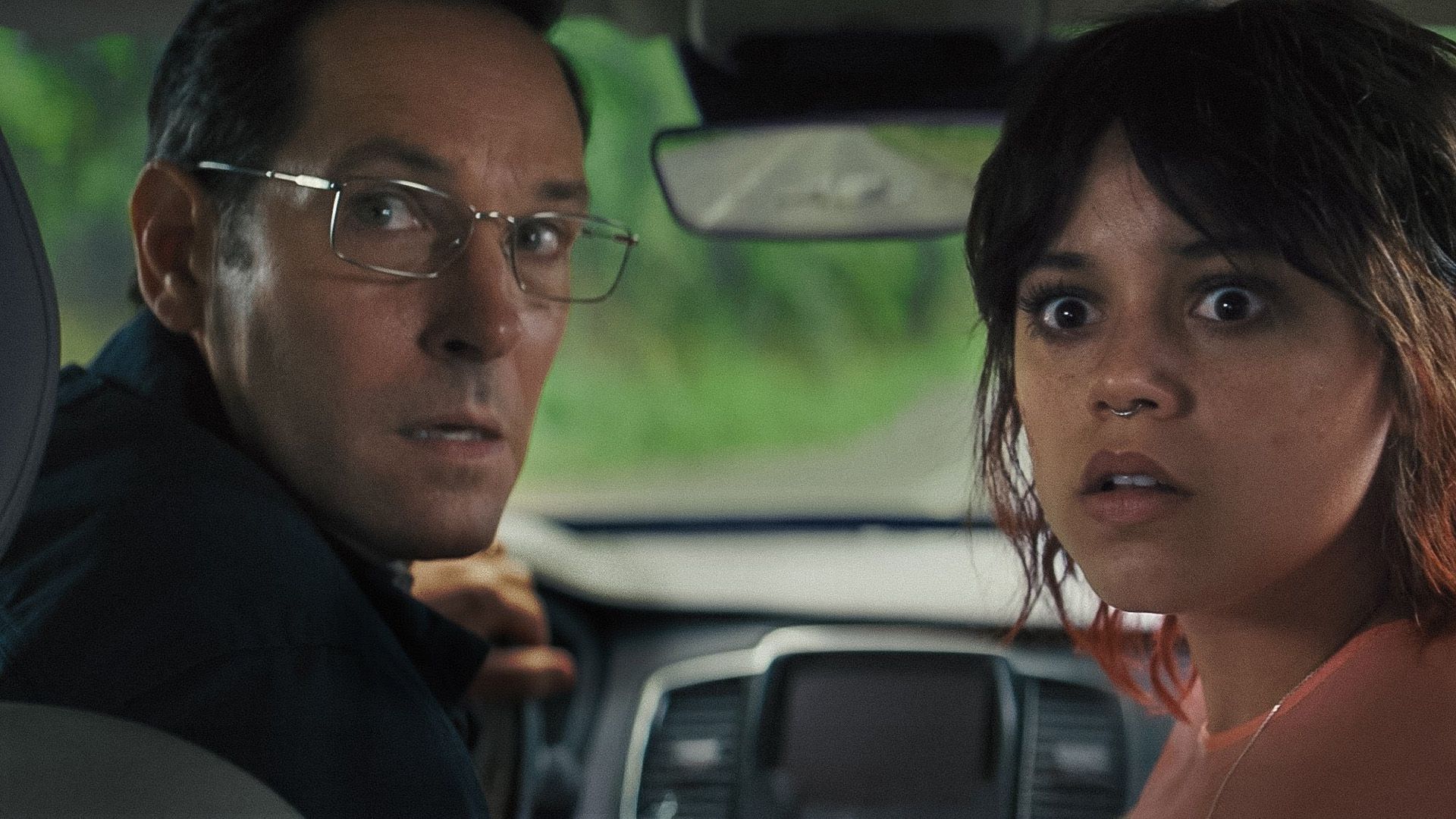 Paul Rudd y Jenna Ortega se giran con caras asustadas mientras están sentados en el coche