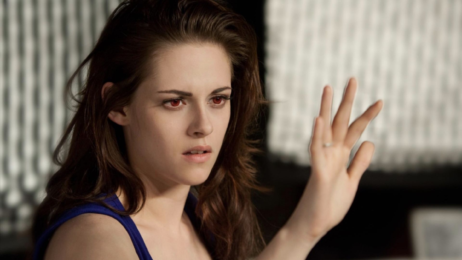 Kristen Stewart como Bella mira su mano con ojos rojos