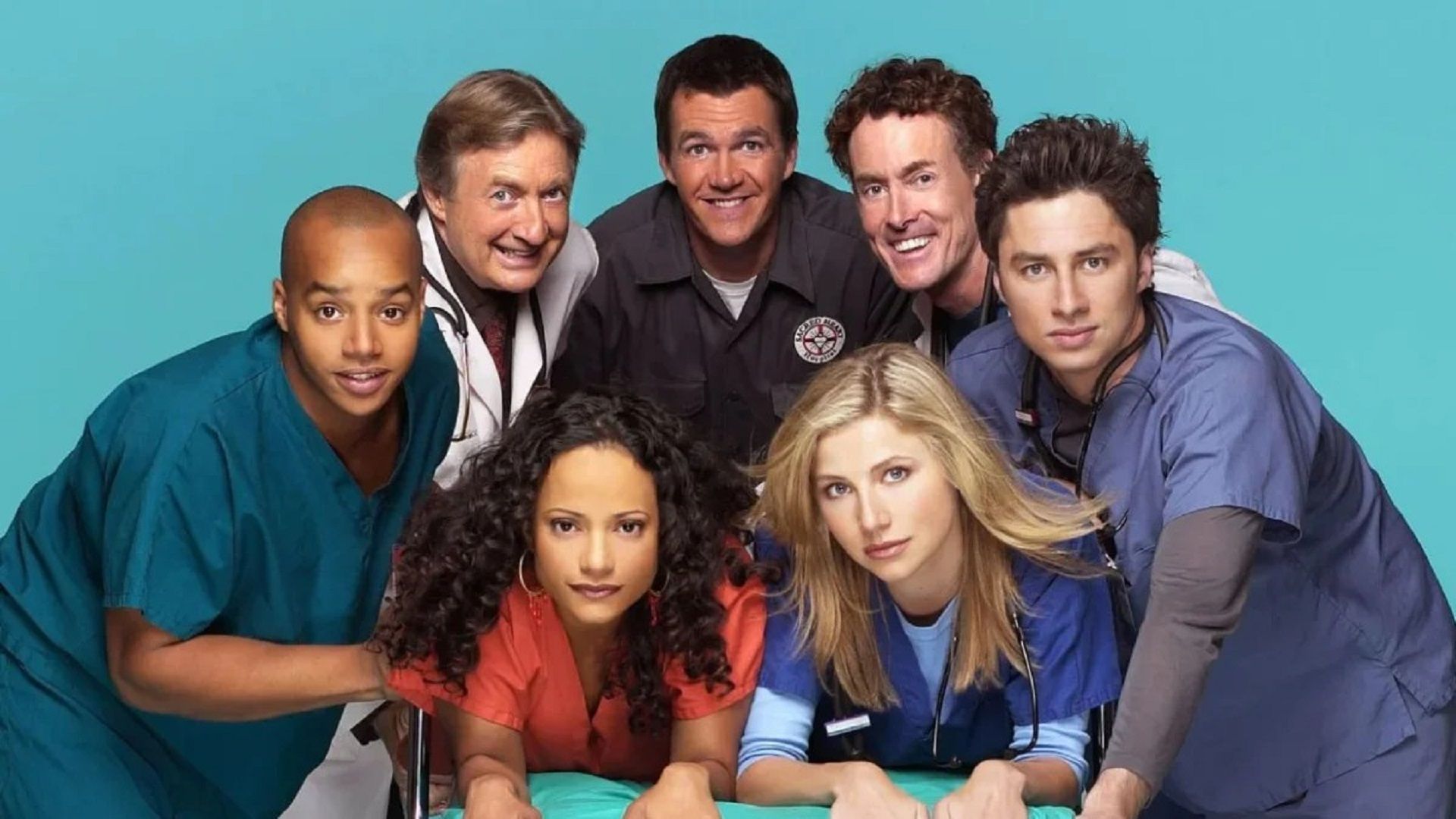 Actores de la serie "Scrubs" como doctores mirando a la cámara