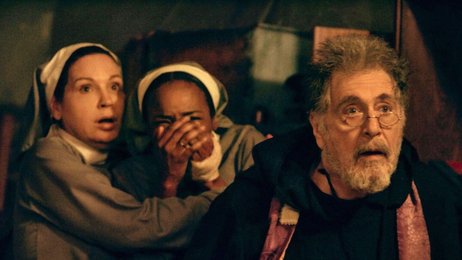 El actor Al Pacino con gafas y una sudadera con capucha negra mira hacia un lado con la boca abierta