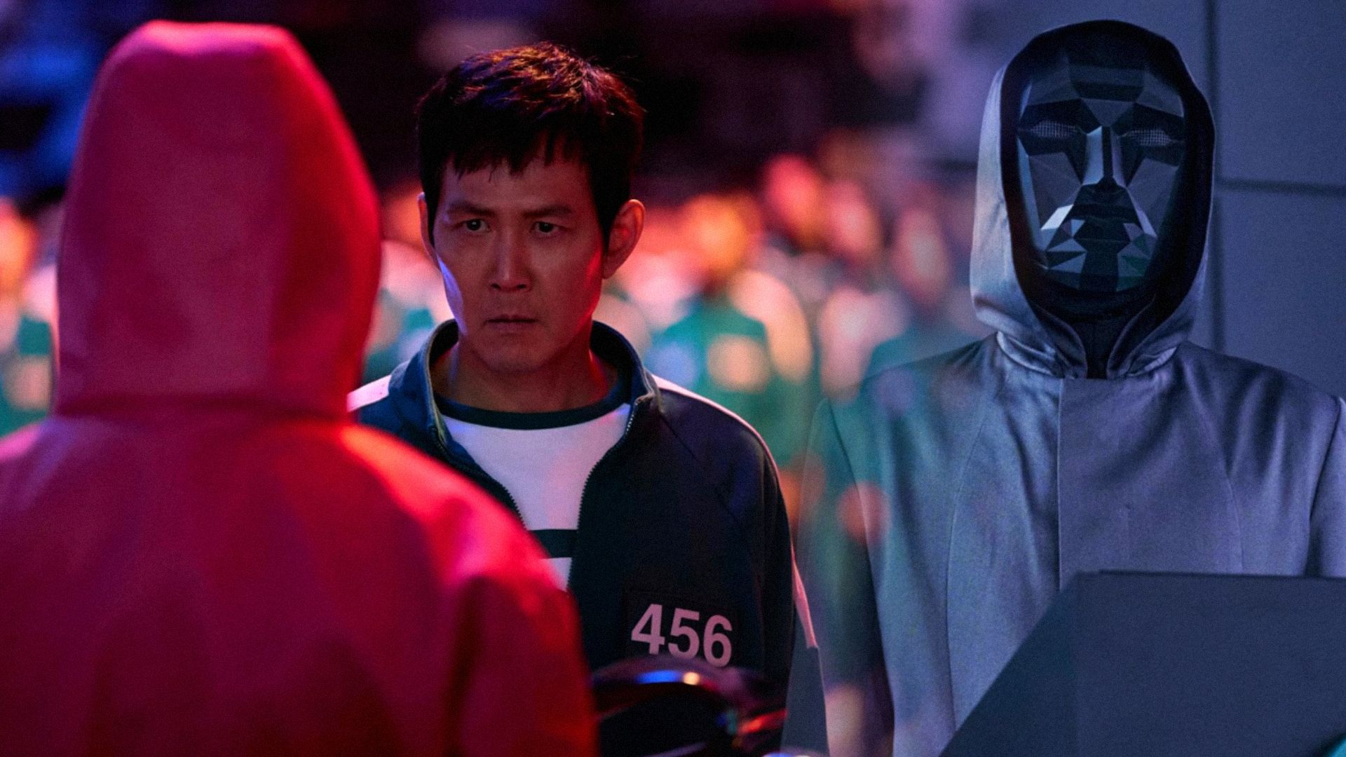 Una persona con máscara negra y el actor Lee Jung-jae con traje verde mirando hacia un lado