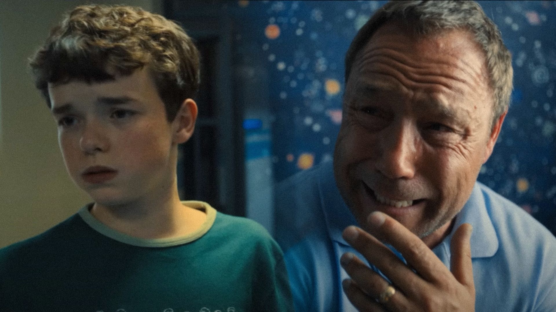 Owen Cooper con ropa verde mira hacia un lado y el actor Stephen Graham llora en una habitación azul