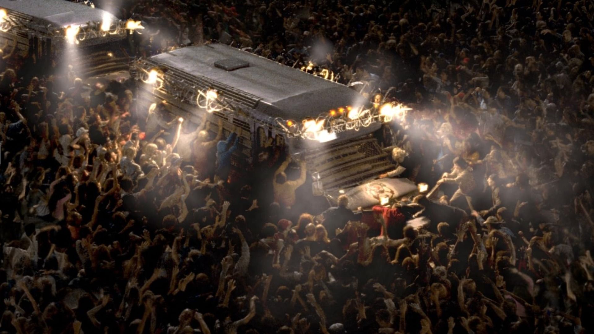 Hordas de zombis rodeando una camioneta blanca por la noche