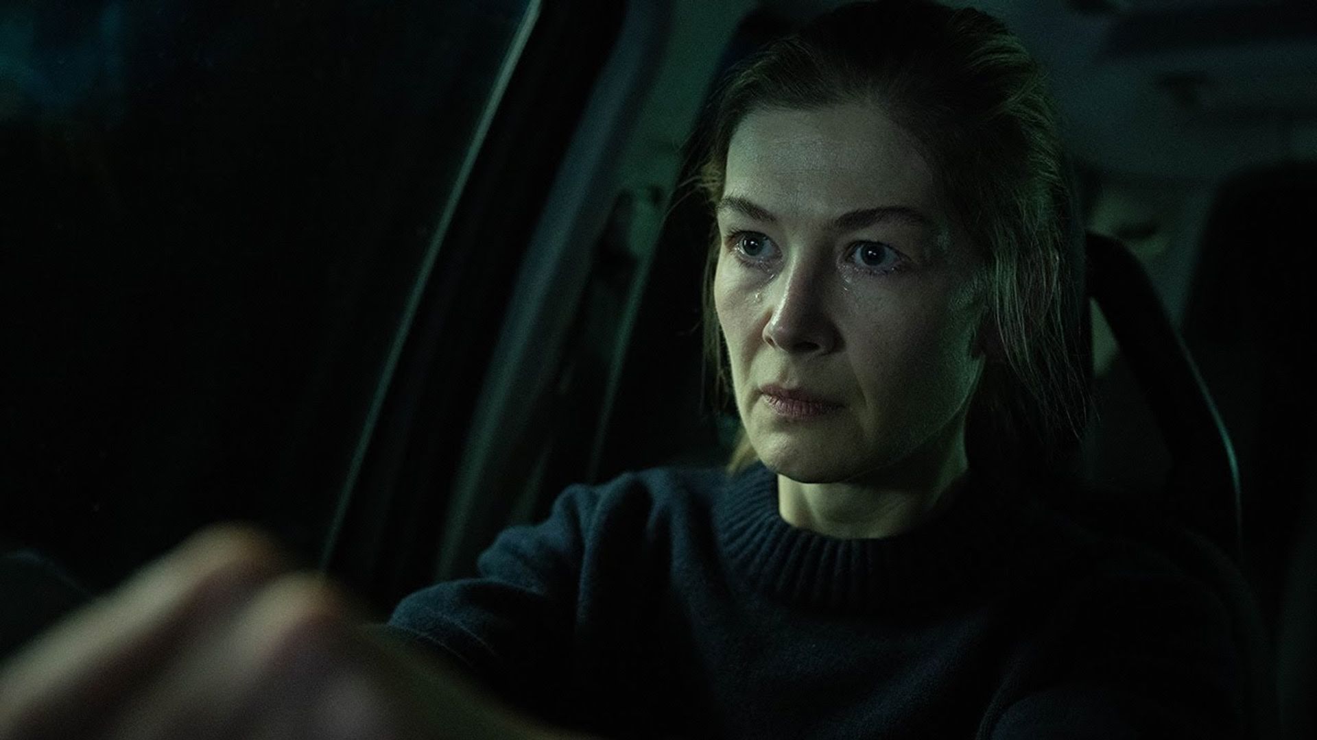 Teléfono en un soporte, la actriz Rosamund Pike sentada al volante de un coche